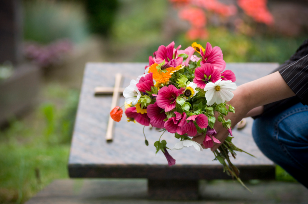 wrongful death claim concept, someone putting flowers on a grave