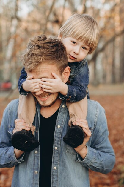 Kid on Father's Shoulders Putting His Fingers on His Father's Eyes