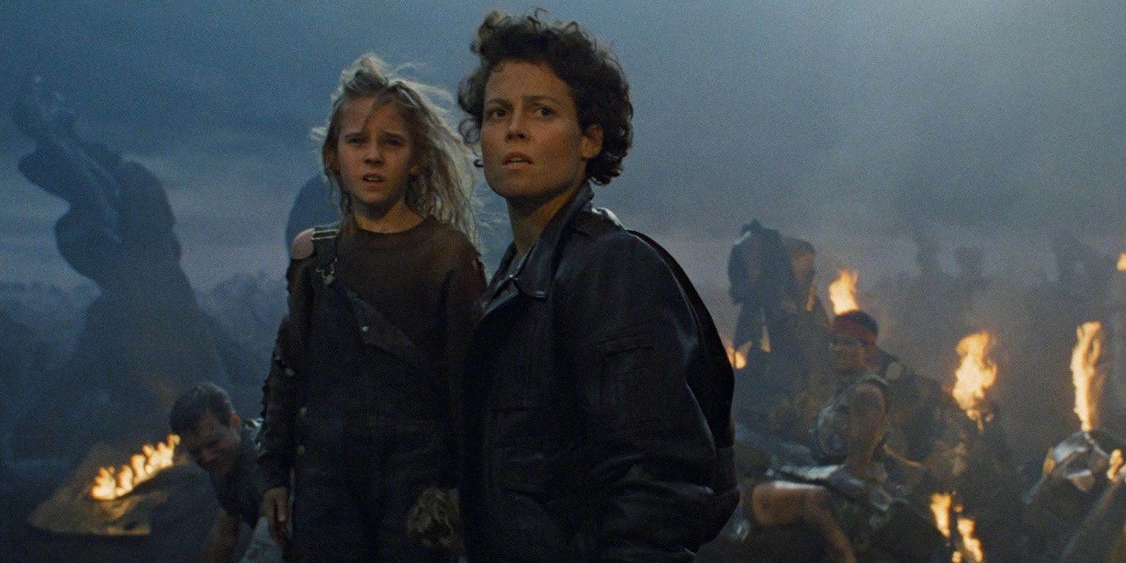 Ripley and Newt stand before wreckage in Aliens