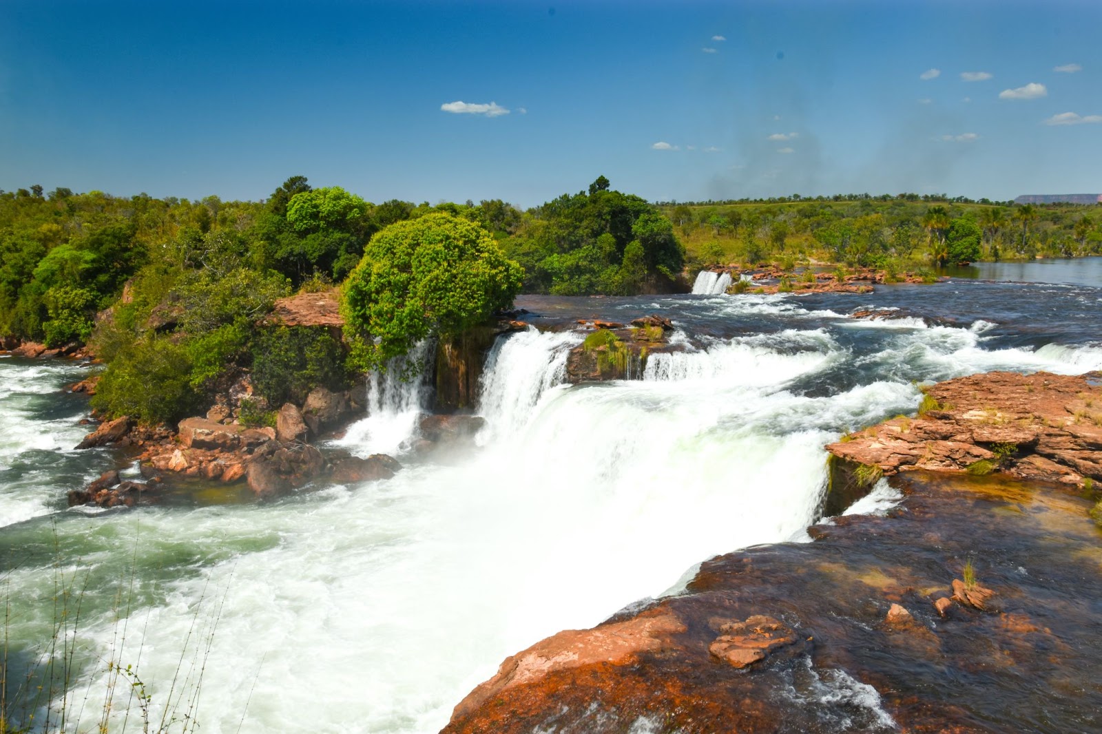 Vista panorâmica de grande cachoeira com queda de alto fluxo de água.