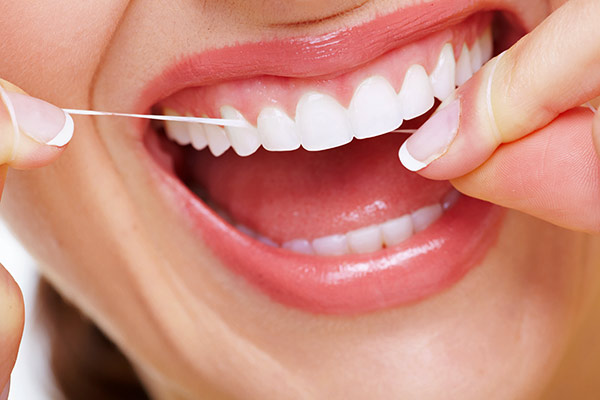 Woman flossing her teeth