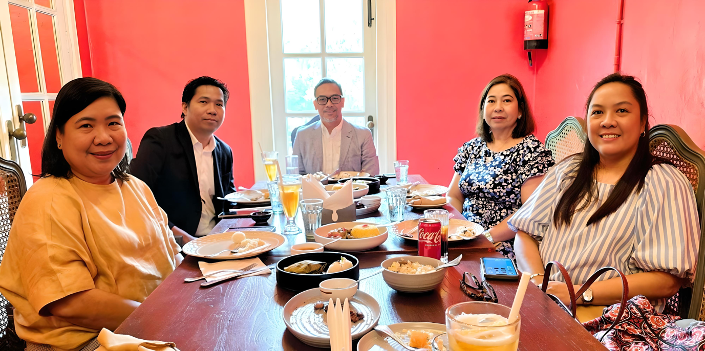 A group of people sitting at a table with foodDescription automatically generated