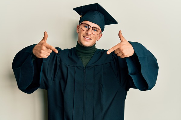 oung grad in cap, confidently pointing with a proud smile