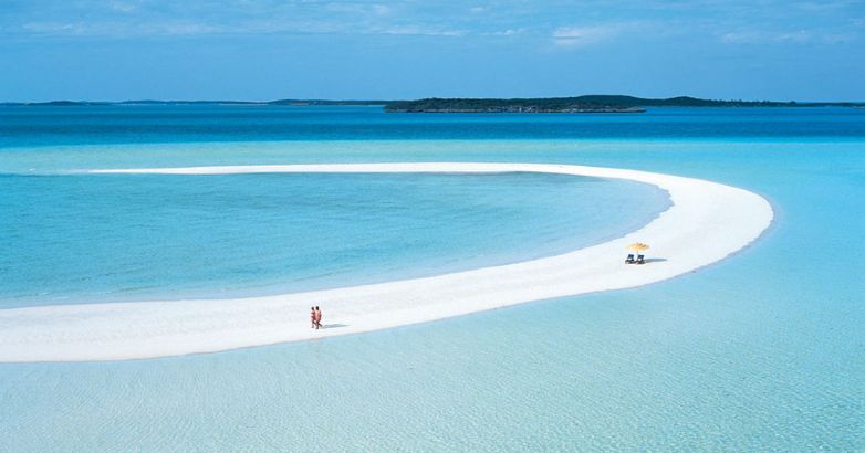 The tourists enjoy the beach with crystal clear water and white sand in Musha Cay