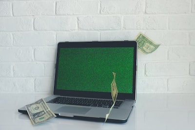 Money and a laptop on a desk