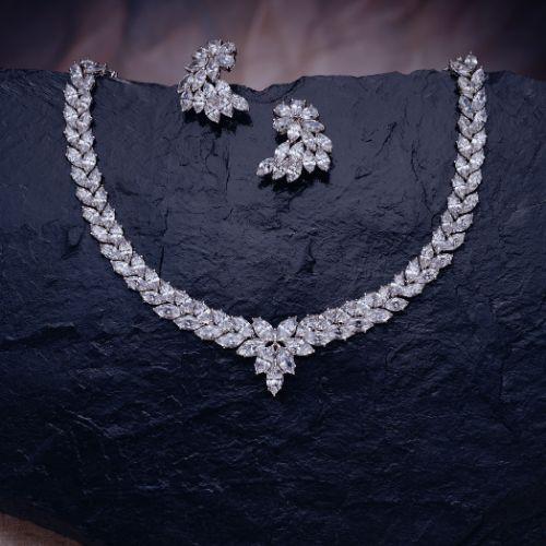 A diamond necklace and earrings on a black surface

Description automatically generated