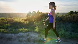 Woman going for a walking workout in nature wearing activewear