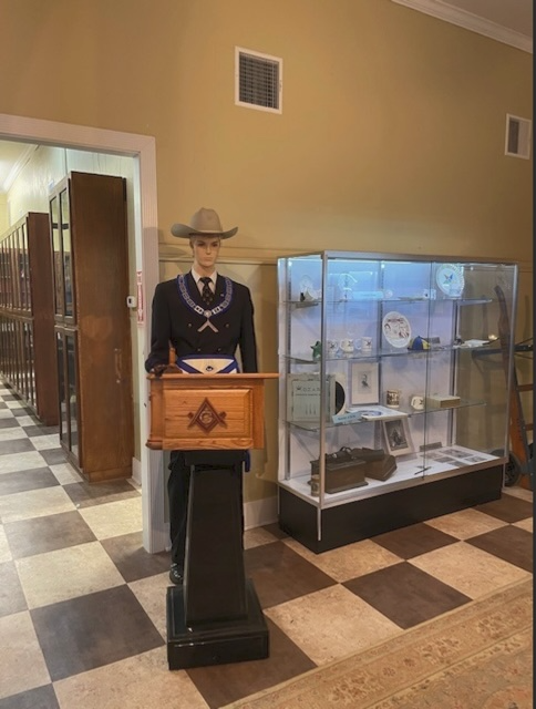 A mannequin wearing a cowboy hat and a square object

Description automatically generated