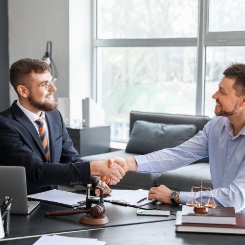 Two men shaking hands at a desk

Description automatically generated