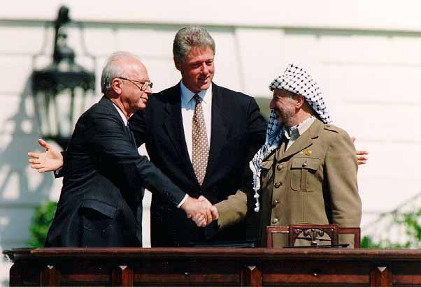 Arafat and Yitzhak Rabin sign Oslo Agreements