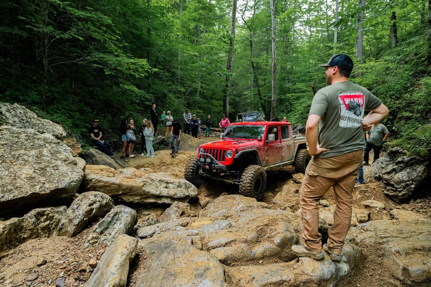 People watching a Jeep at an off-roading event 