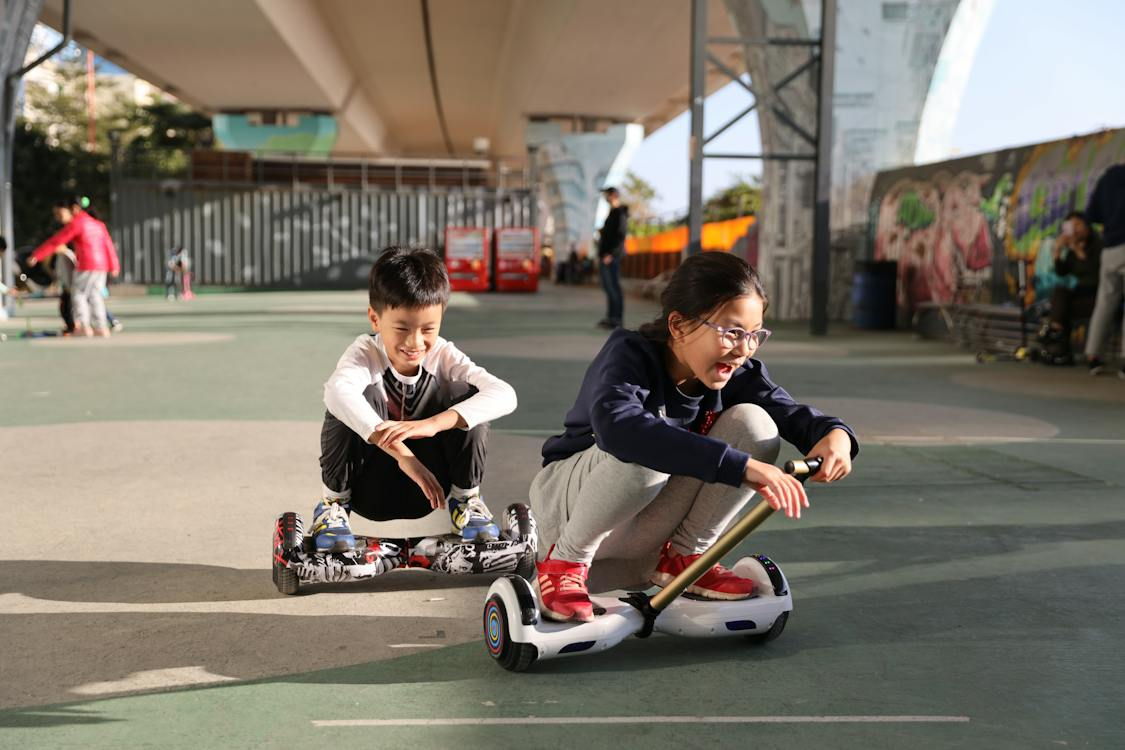 two young kids riding hoverboards
