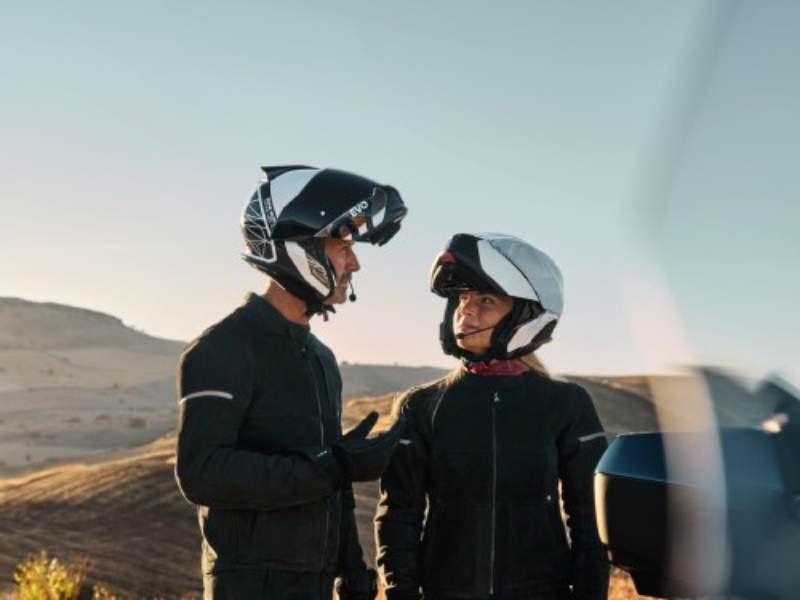 Motorradfahrer mit BMW Motorradbekleidung tragen einen System 7 EVO Helm mit Intercom