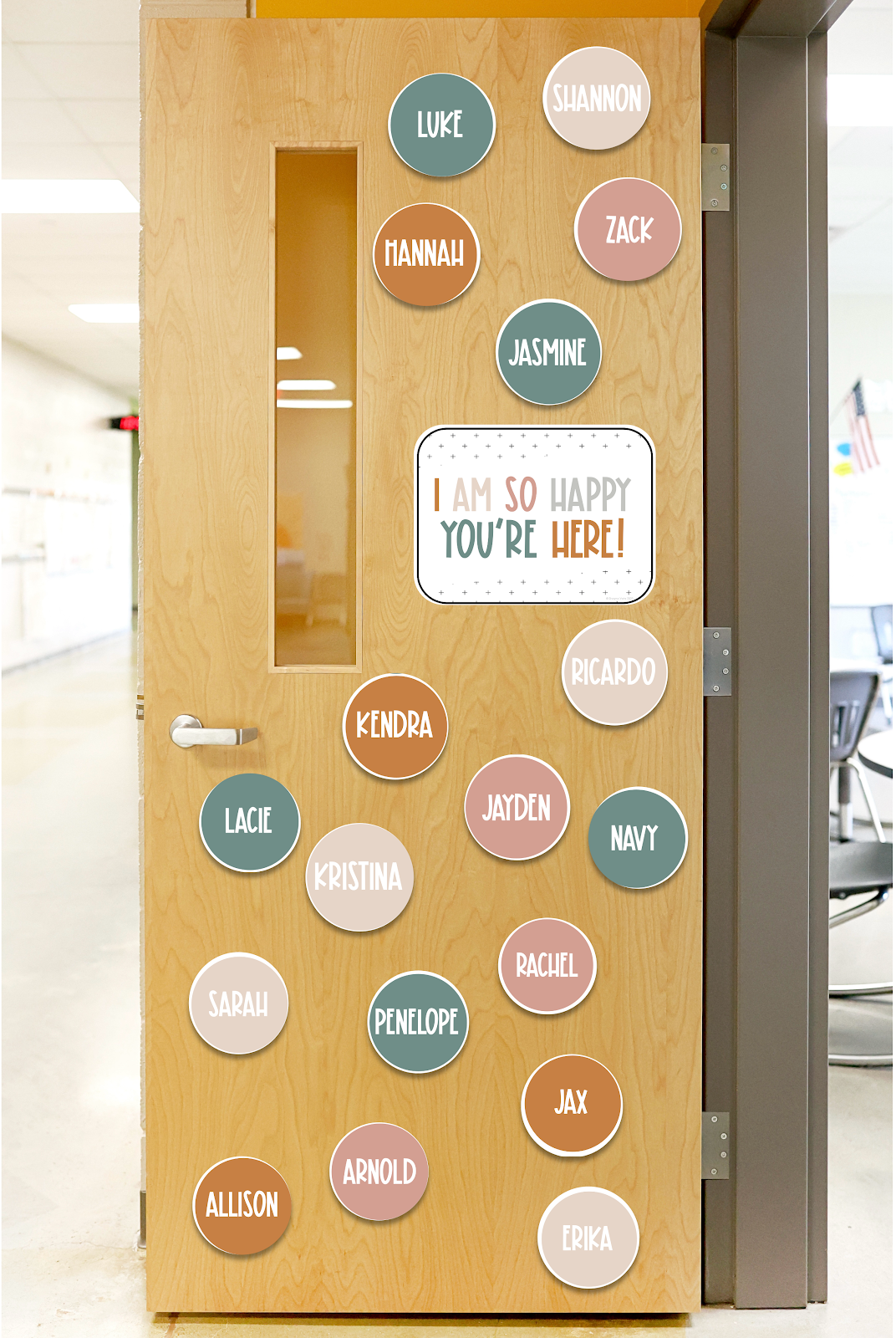 This image shows a classroom door with neutral-colored circles covering the door. Each circle has the name of one student written on it. In the middle of the door is a poster that reads "I am so happy you're here!" 