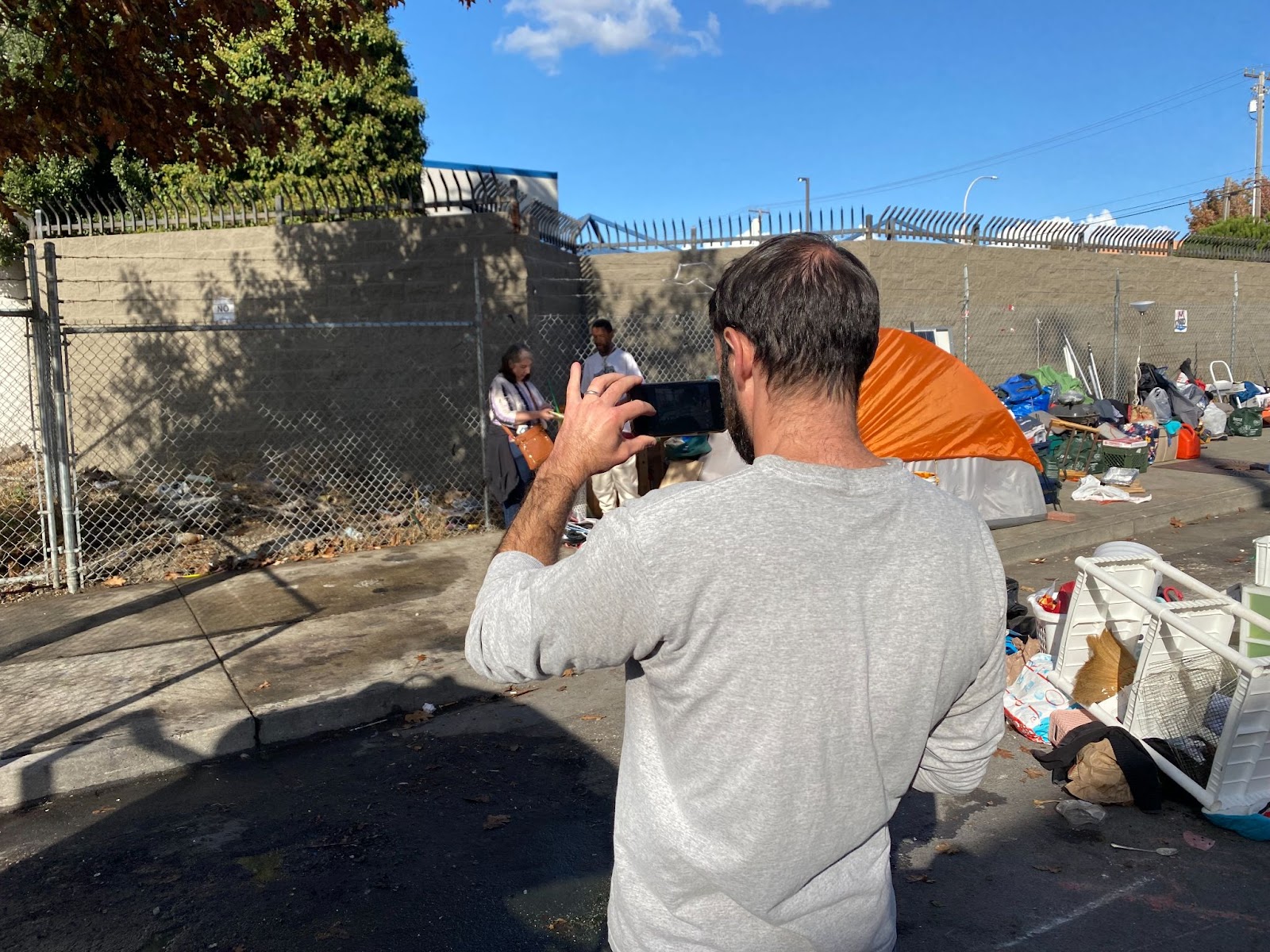 Assistant to the city manager, Peter Radu, photographs Clarence Galtney as he speaks with a local homelessness advocate, November 7, 2023. (Bradley Penner)