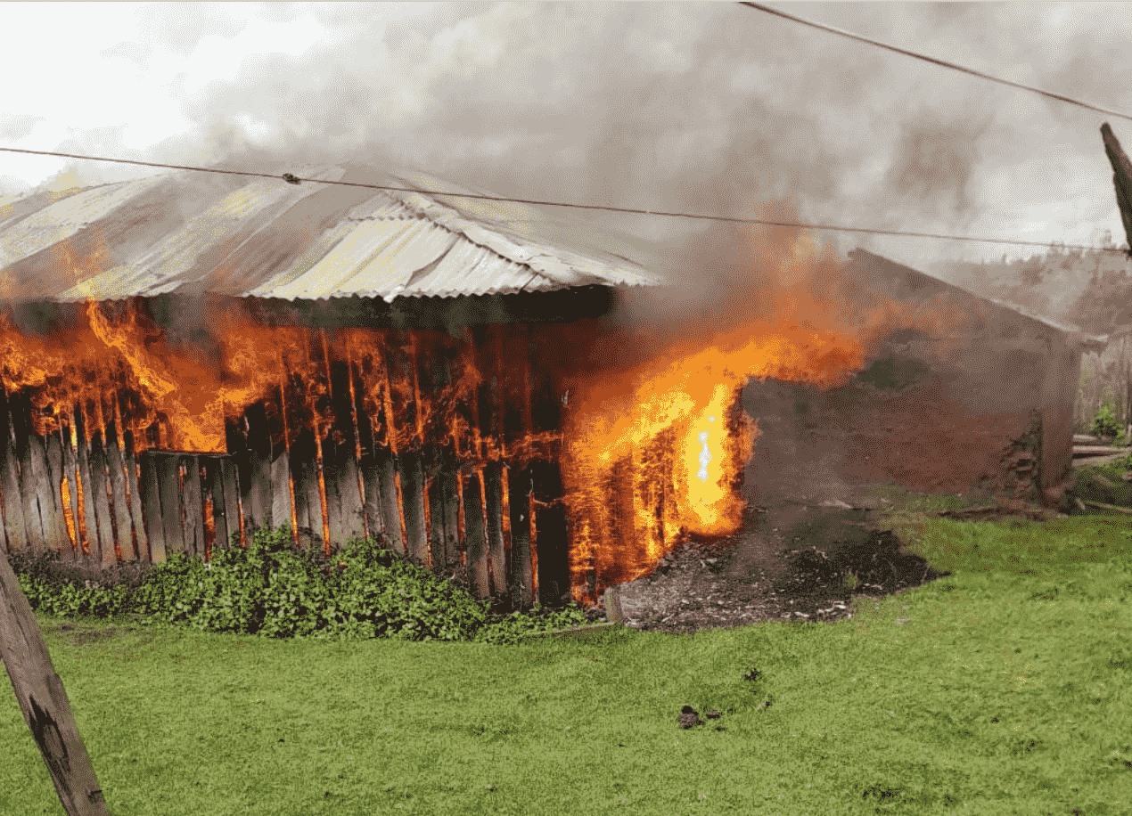 A wooden house is swallowed by flames and smoke