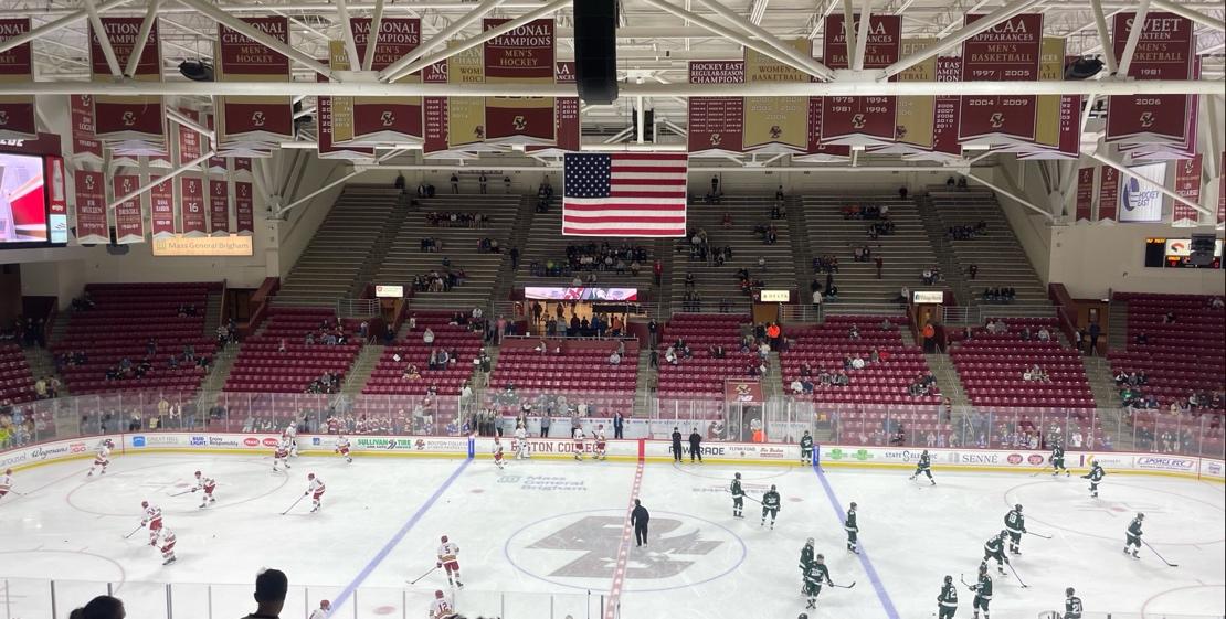 A hockey arena with a flag from the ceiling

Description automatically generated