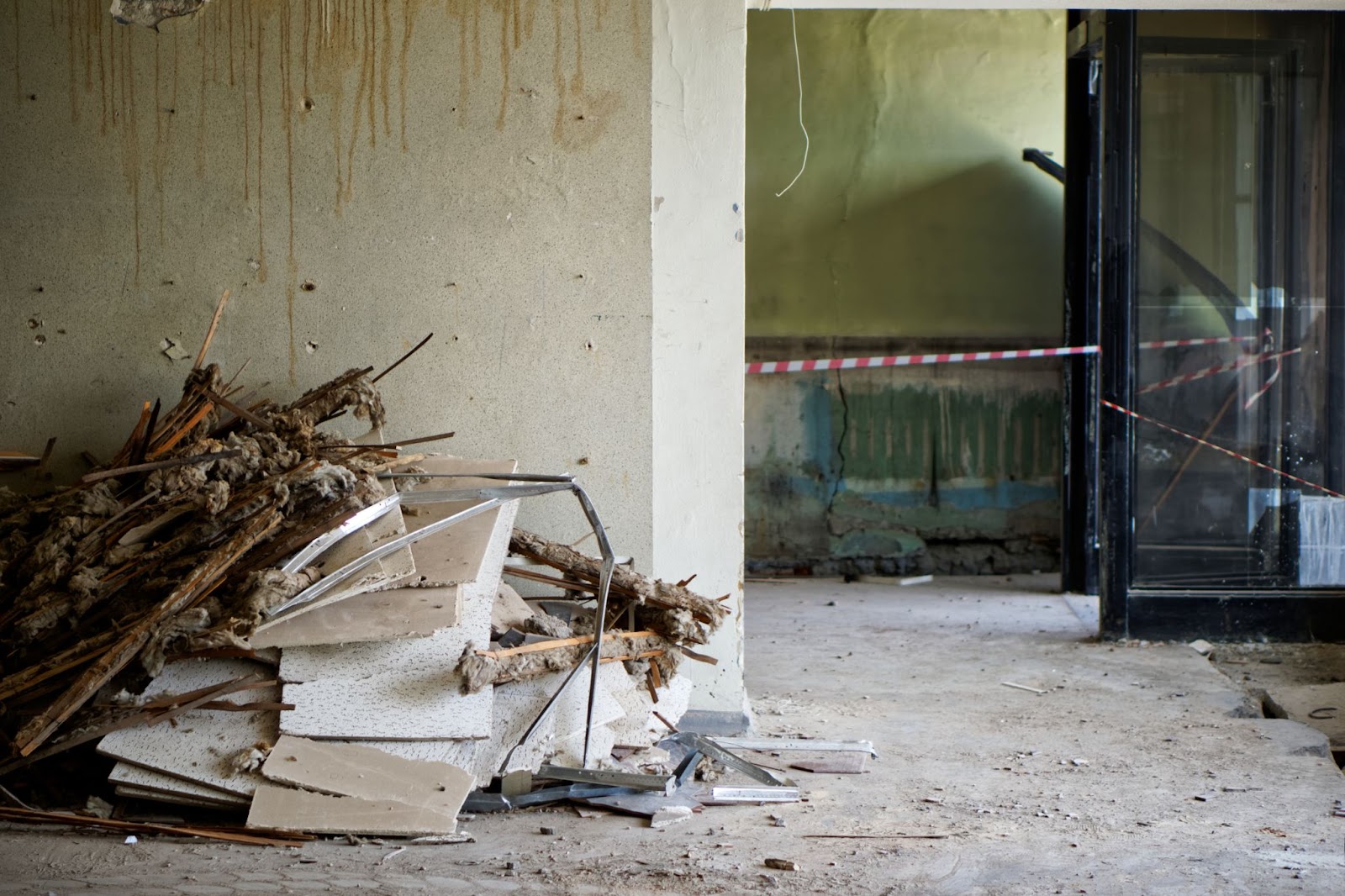 A pile of rubble in an abandoned room, showcasing the expertise of disaster restoration professionals.


