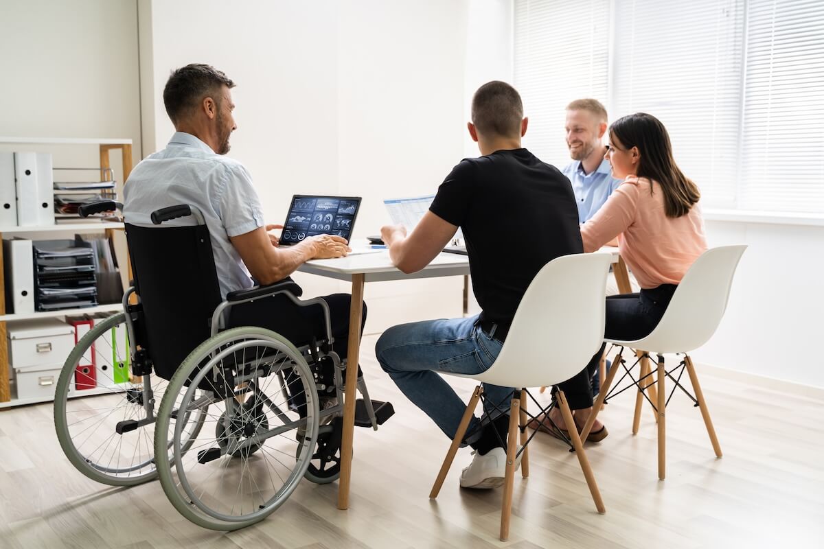 ADA confidentiality requirements: employee in a wheelchair working with his colleagues