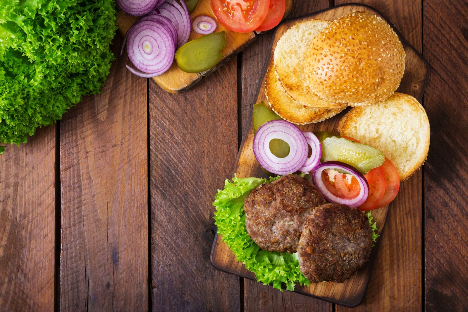 A Build Your Own Burger Board is a great Board Presentation Idea For a Dinner For Two, The Board Pictured Features Burger Patties, Buns, and Toppings.