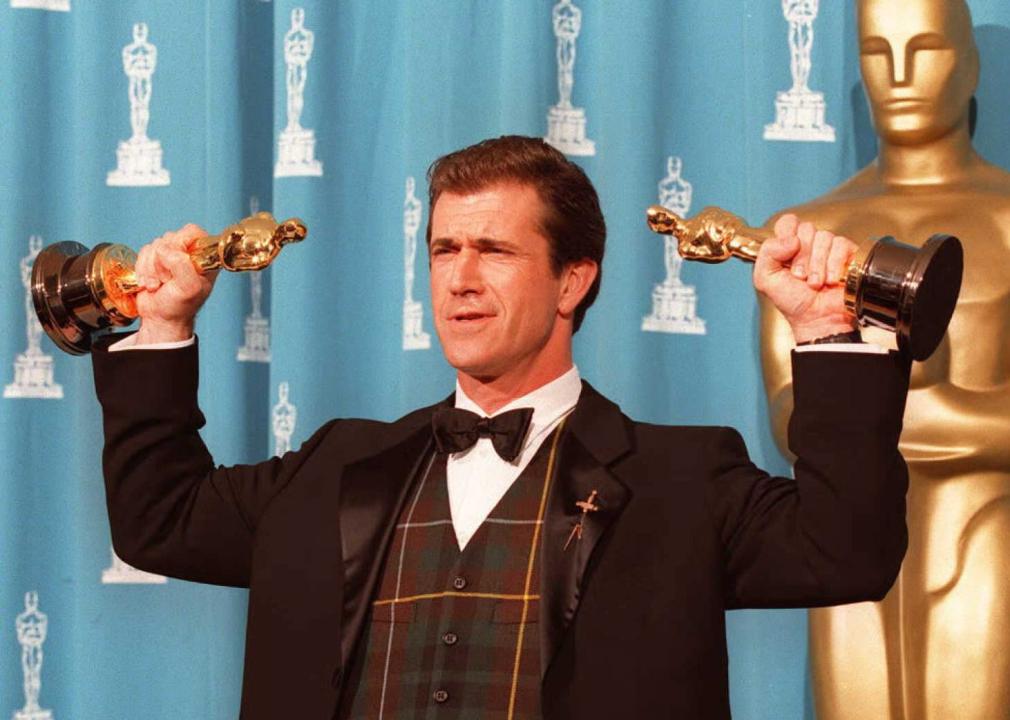 Mel Gibson holds his two Oscars at the Academy Awards.