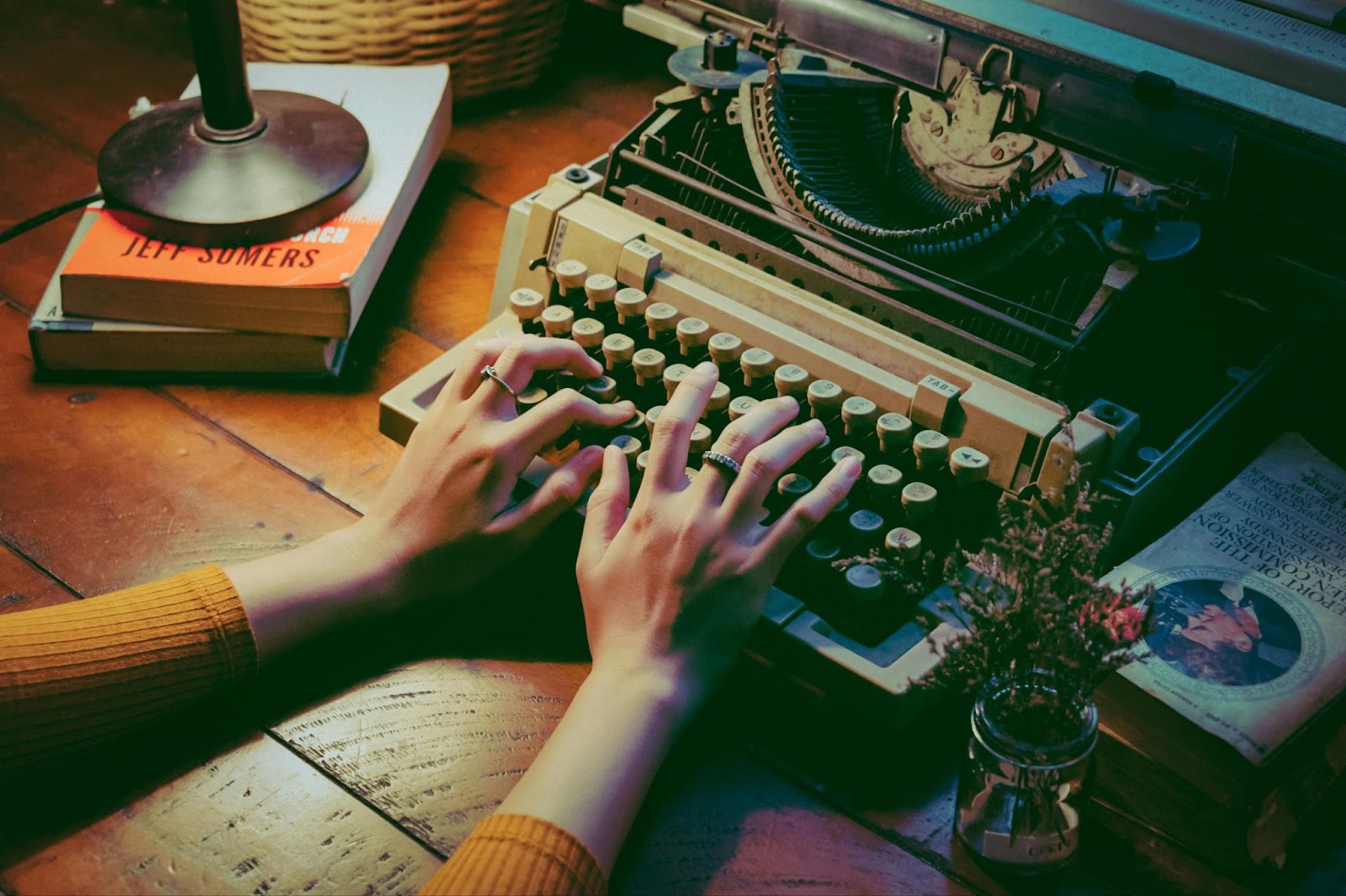 A woman’s hands typing on an old typewriter machine