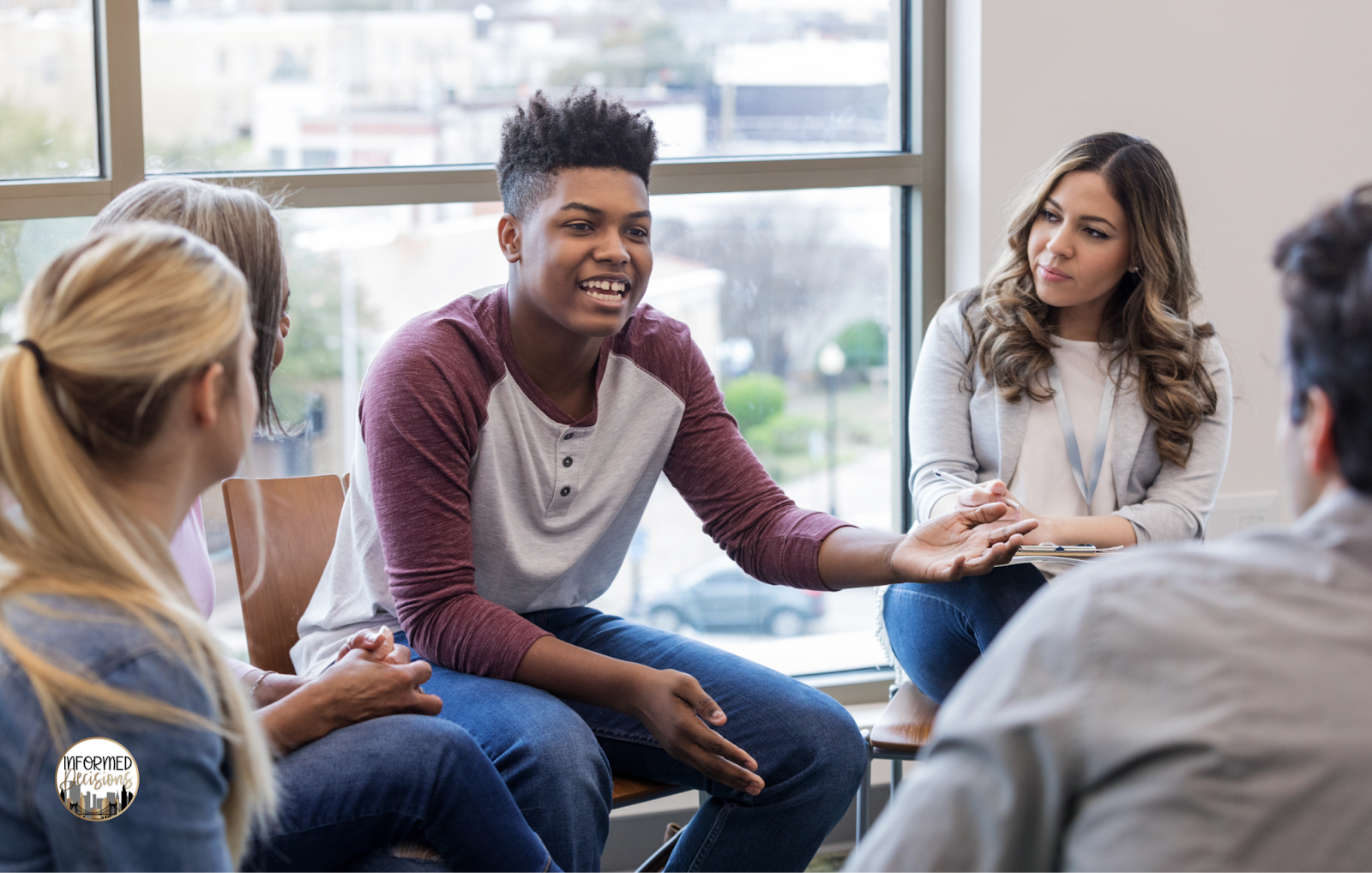 Teen boy speaking to his group in class. 