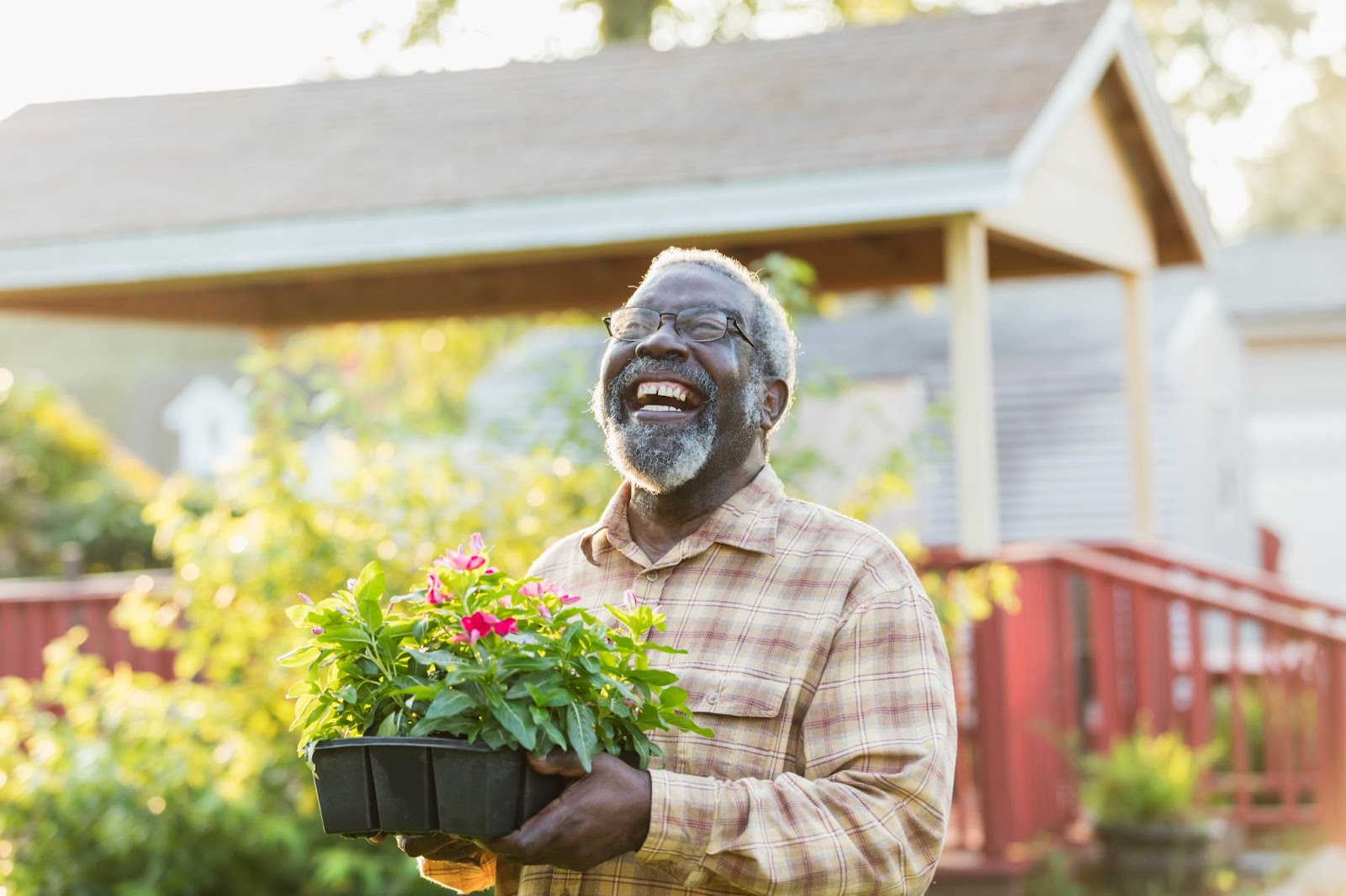 senior man smiling while sharing flower trays