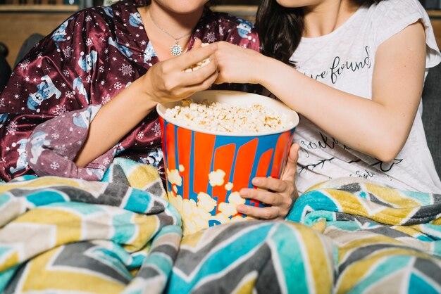 Free photo close-up of a two women sharing popcorn