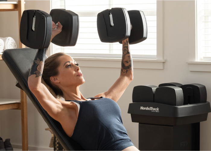 Woman Lifting NordicTrack Adjustable Weights and Using Strength Training for Longevity