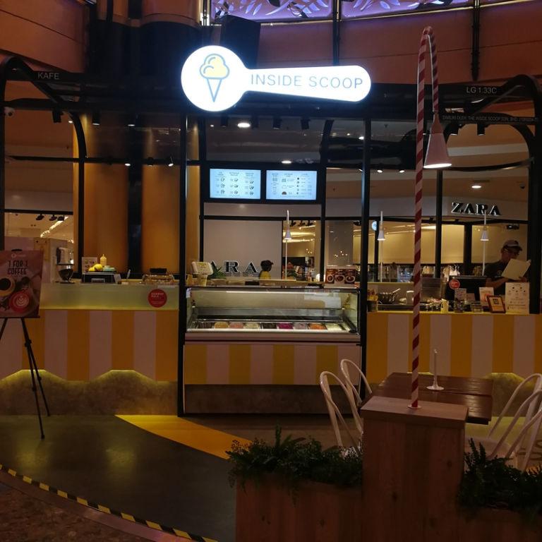 A yellow and white ice cream stand

Description automatically generated