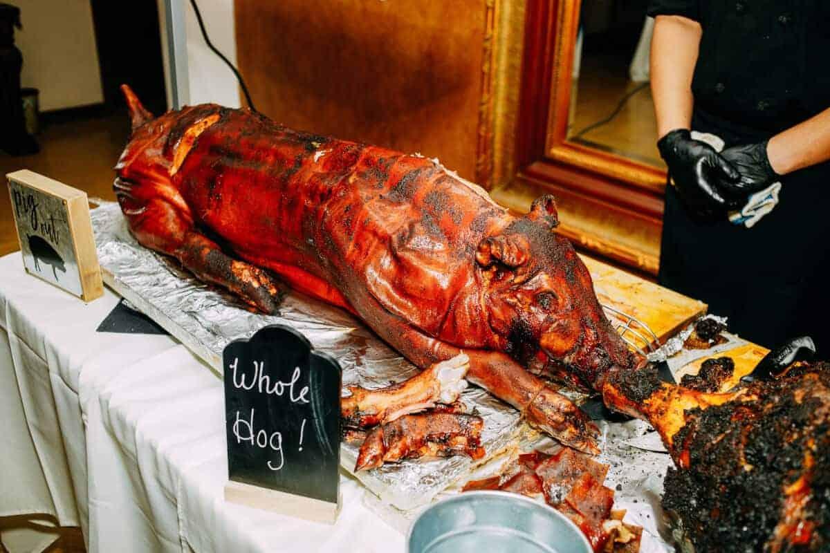Un porc întreg afumat, întins pe o masă