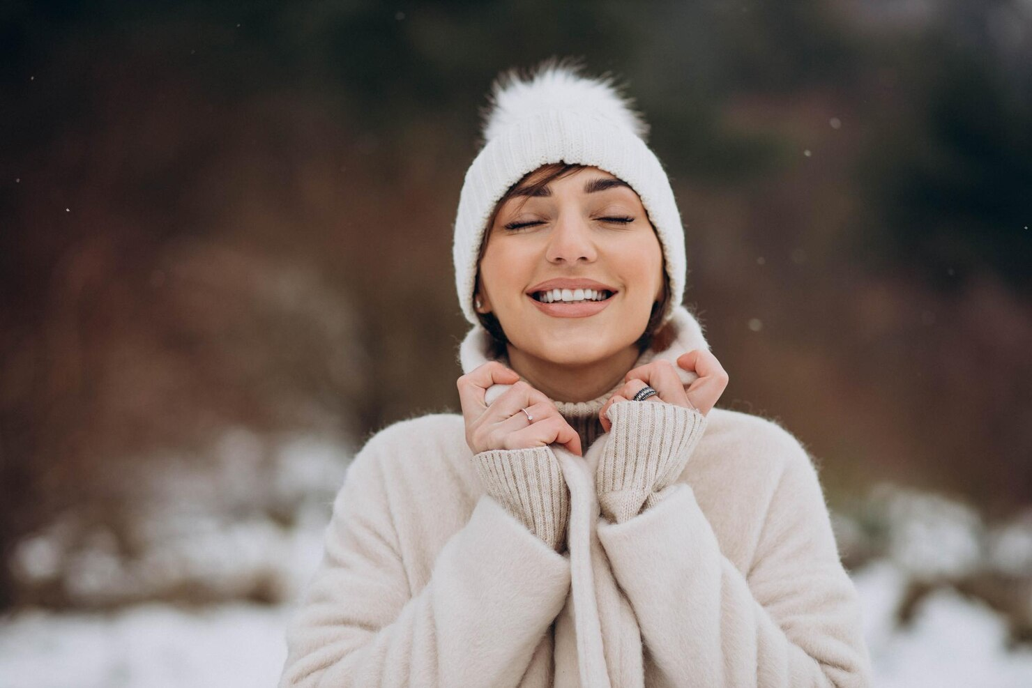 A woman in a winter hat smiling on a cold day.