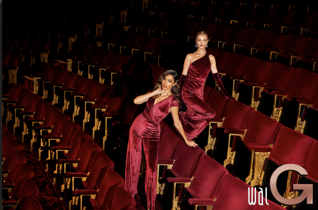 امرأتان ترتديان فساتين حمراء في مسرح فارغ تم إنشاء الوصف تلقائيًا