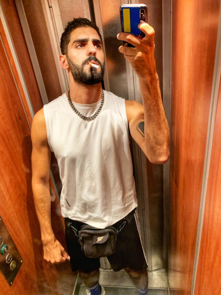 karim yoav taking a mirror selfie in the elevator smoking 