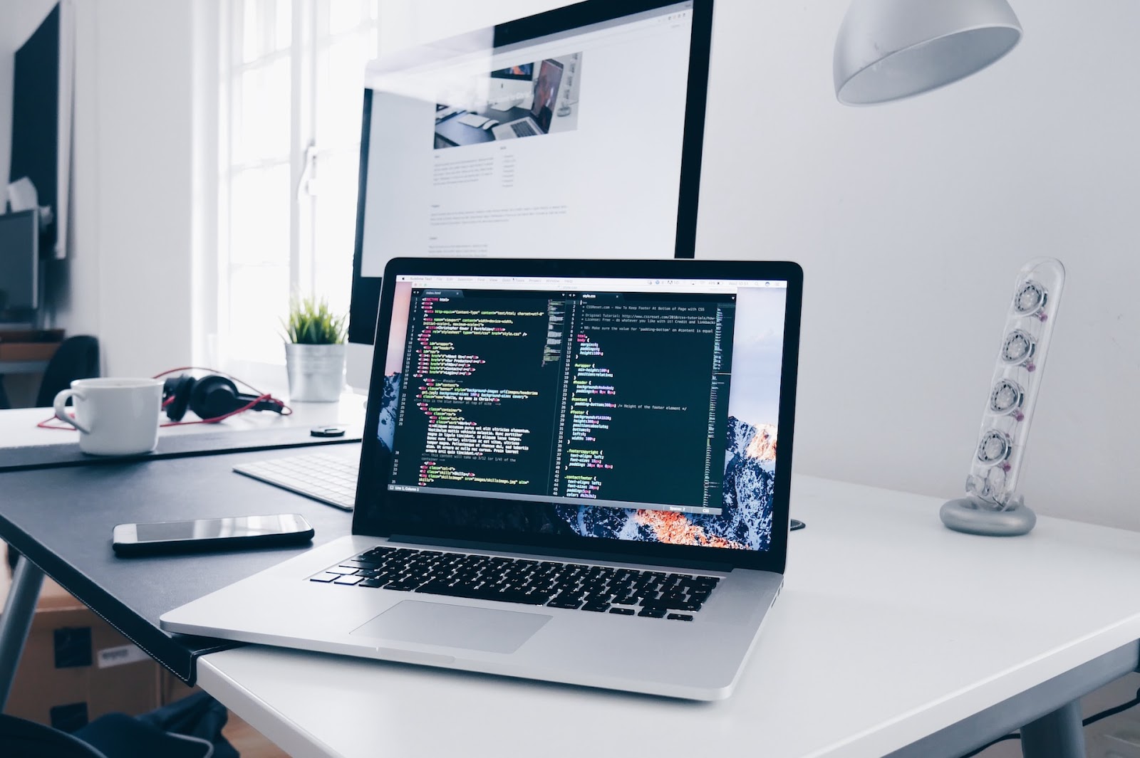 Photo by Christopher Gower on Unsplash - computer on desk showing code
