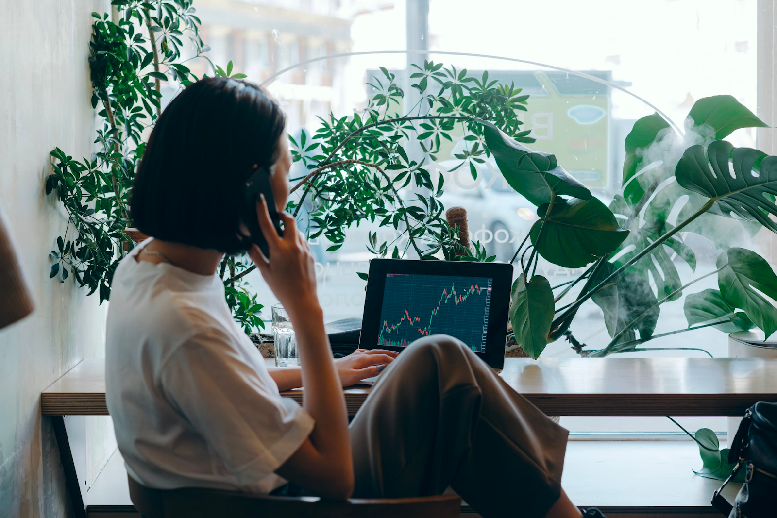 A woman relaxing at a coffee shop while looking at her investment options