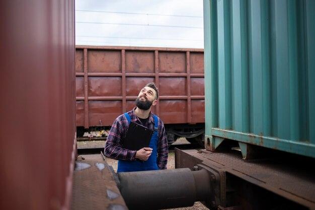 Railwayman checking train trailers before departure