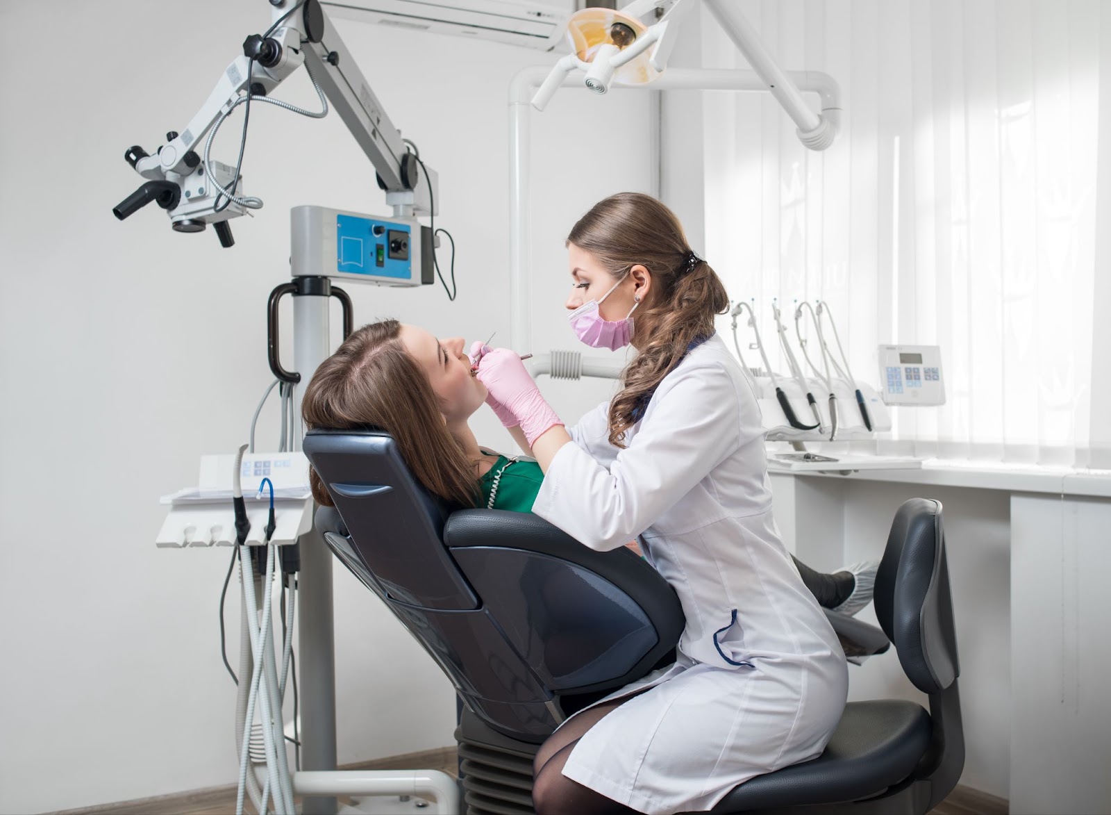 A female dentist holding dental tools, a mirror, and a probe, ready to perform a dental examination.