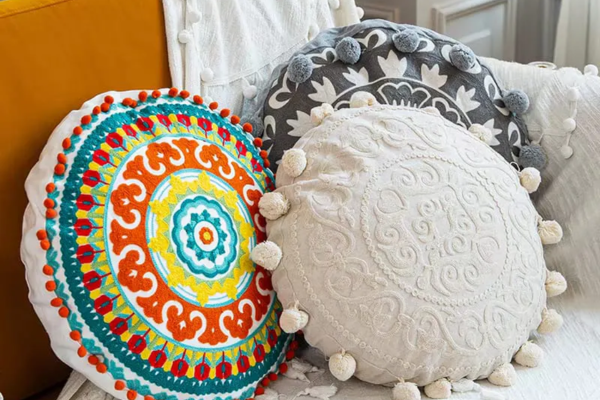 Embroidered round cushion with pom-pom trim, crafted from teddy fleece and velvet
