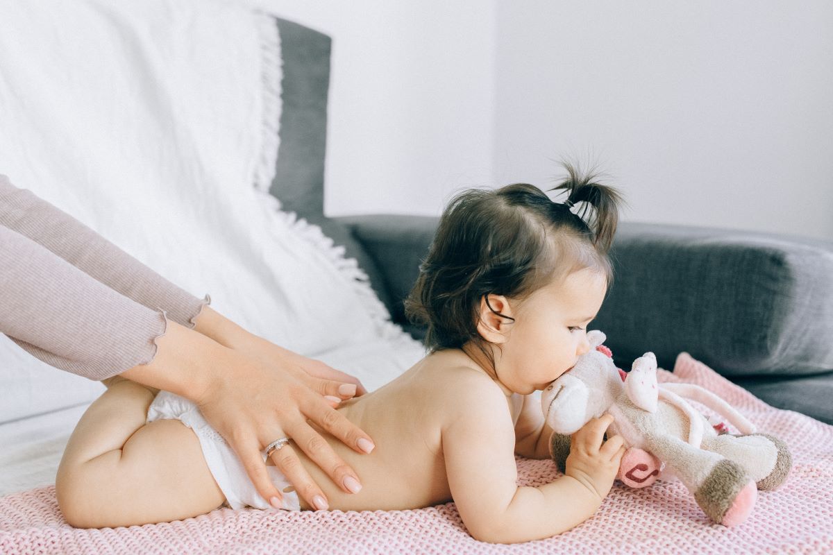 baby enjoying massage from mom