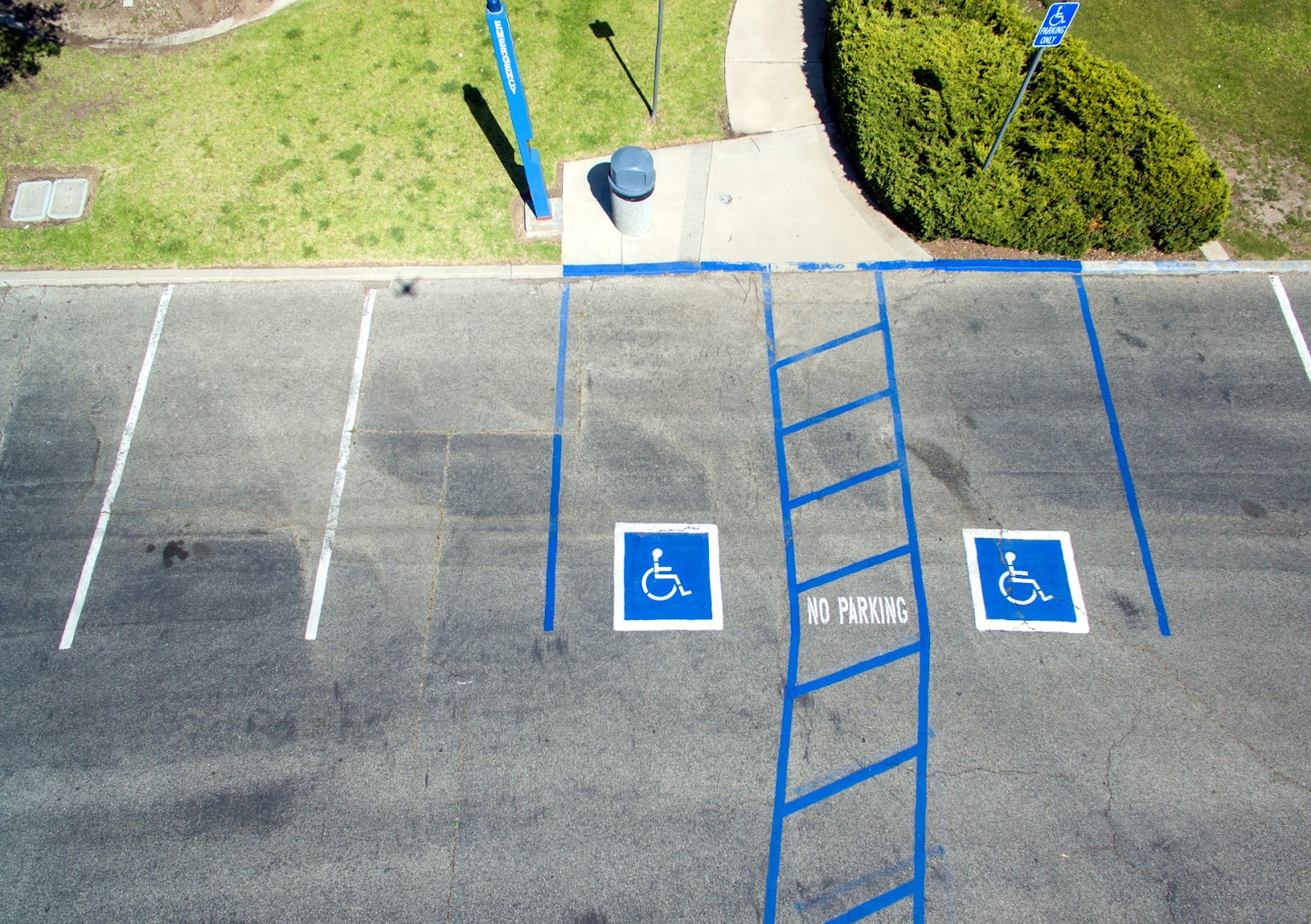 A photo of a parking lot featuring two spots for individuals with mobility disabilities. 