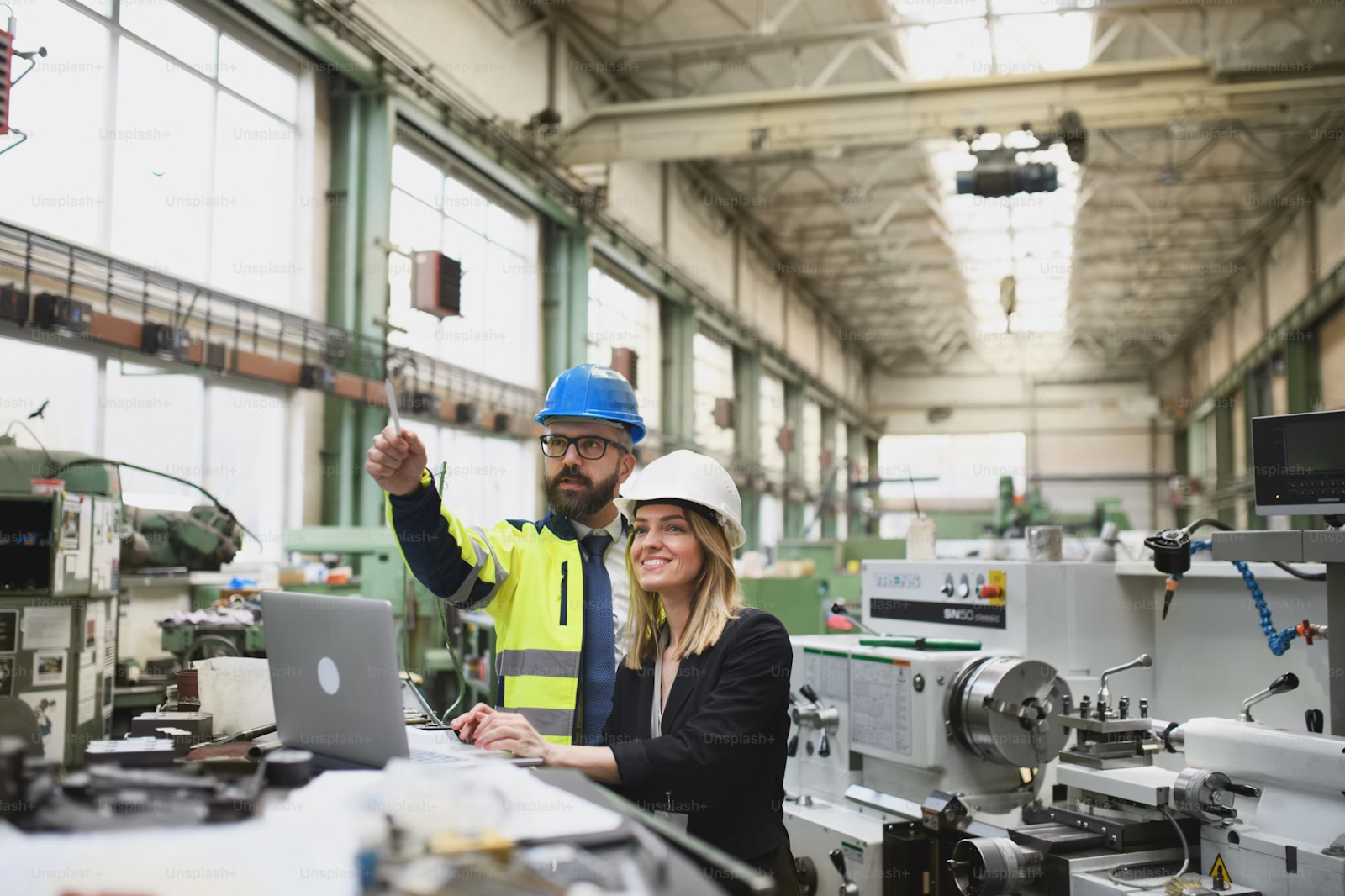 Fábrica do futuro: homem e mulher olhando equipamentos em uma indústria