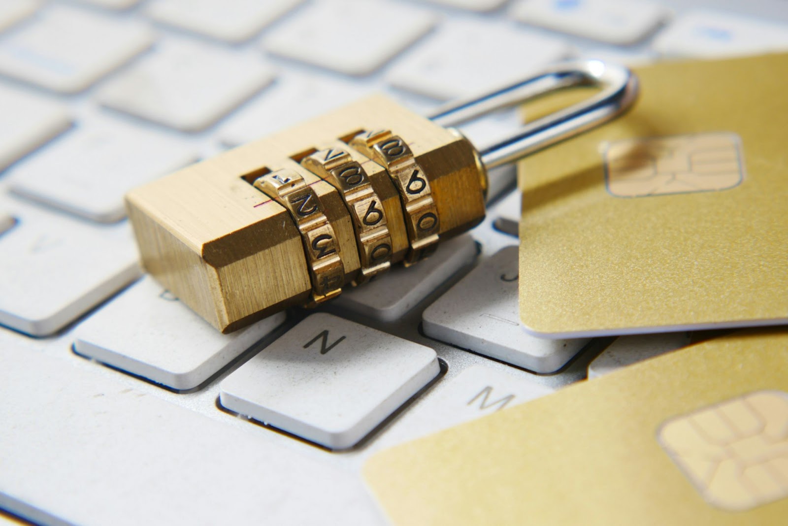 A padlock and a credit card on a computer keyboard