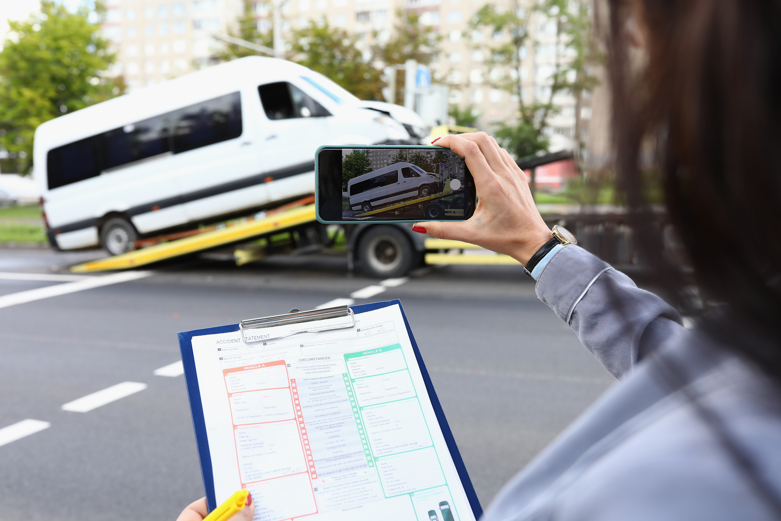 insurance adjuster taking a picture of a damaged van