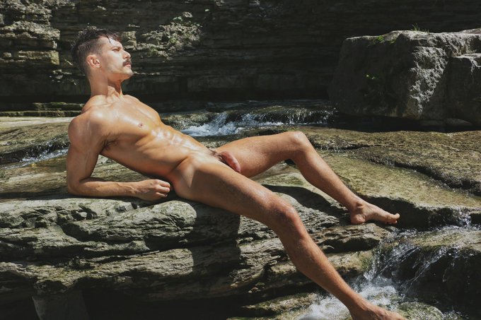 william miguel lying naked on the rocks outside looking at the sun
