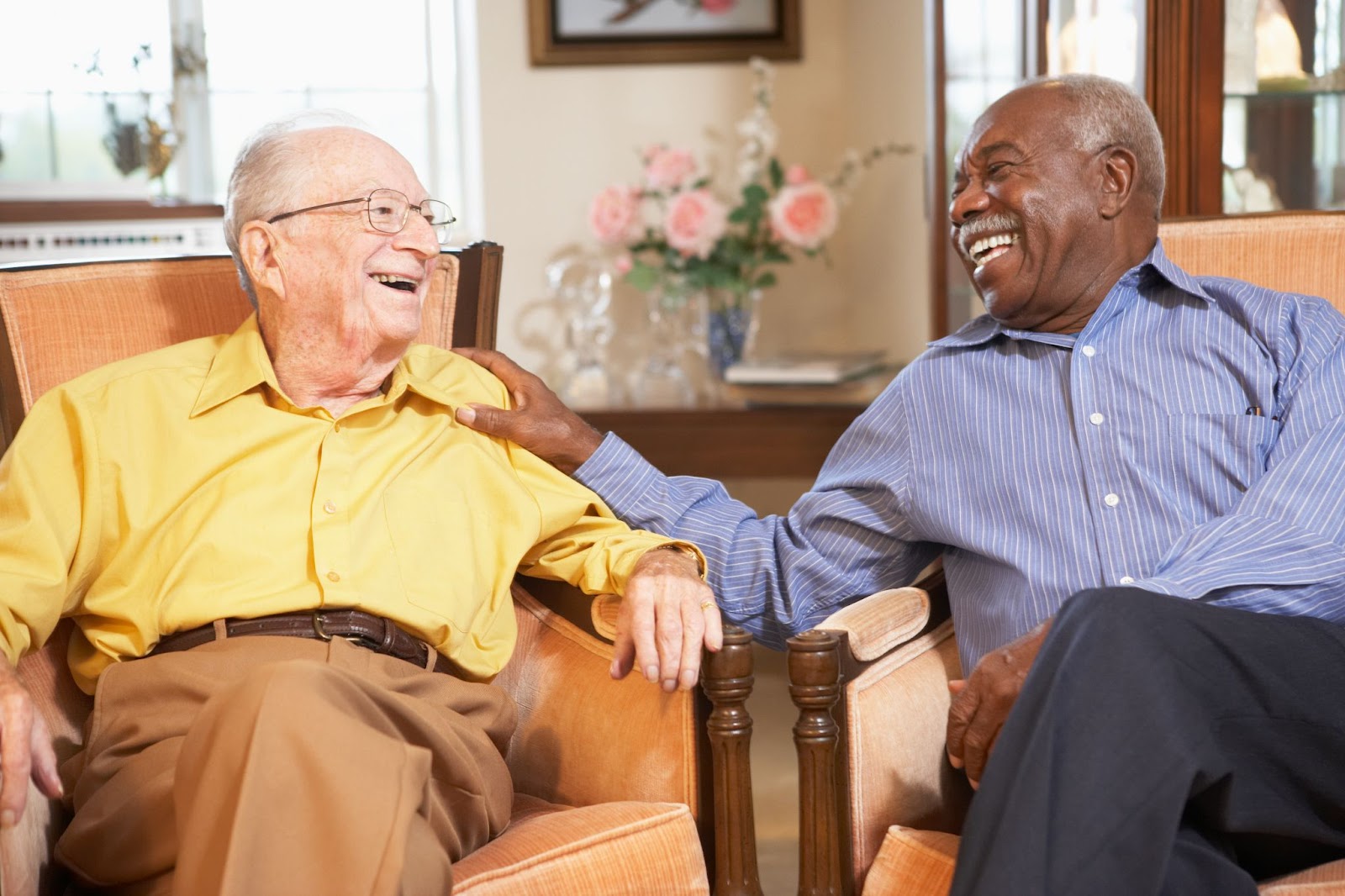 senior man with friend sitting in chairs