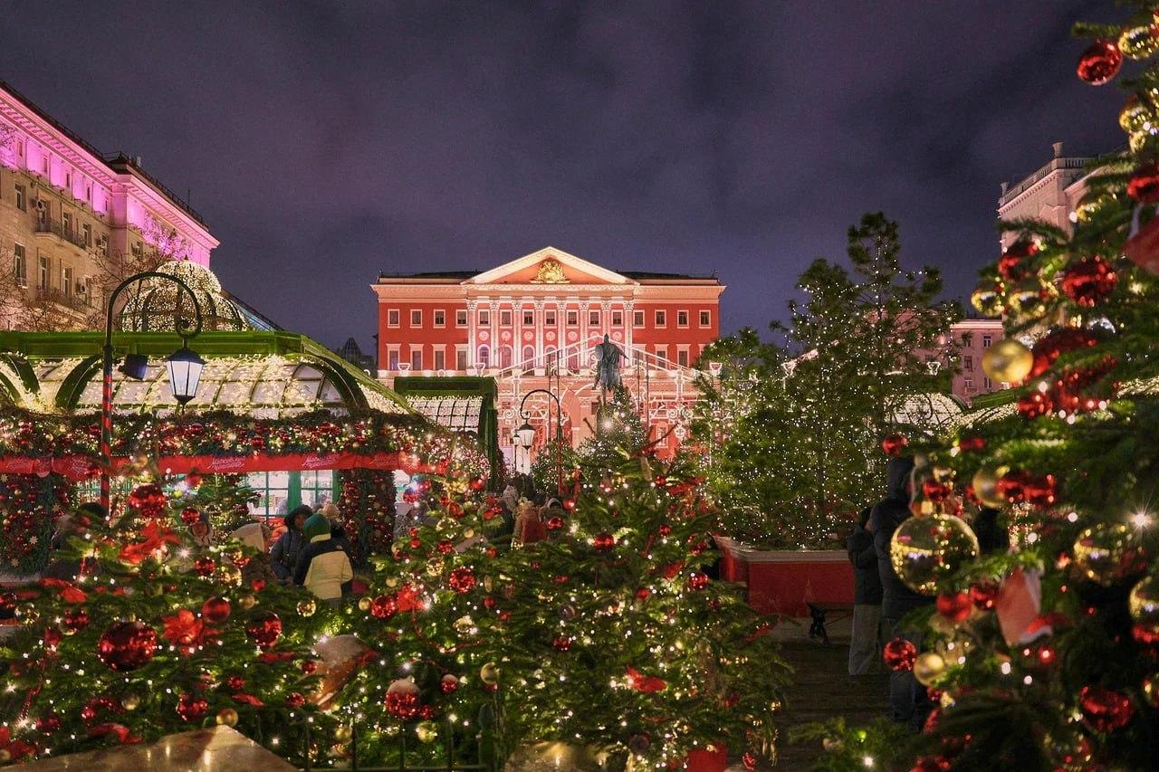 A group of people in front of a building with christmas trees

Description automatically generated