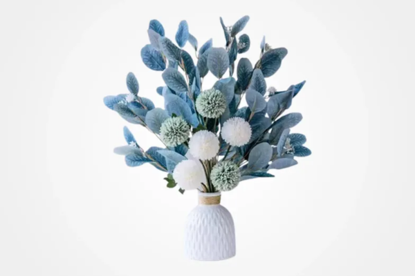 Textured white ceramic vase holding an arrangement of artificial blue and white flowers