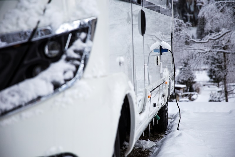 RV parked at a campground in the snow
